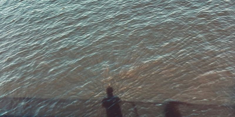 Silhouette of a person meditating against a calm, abstract background.